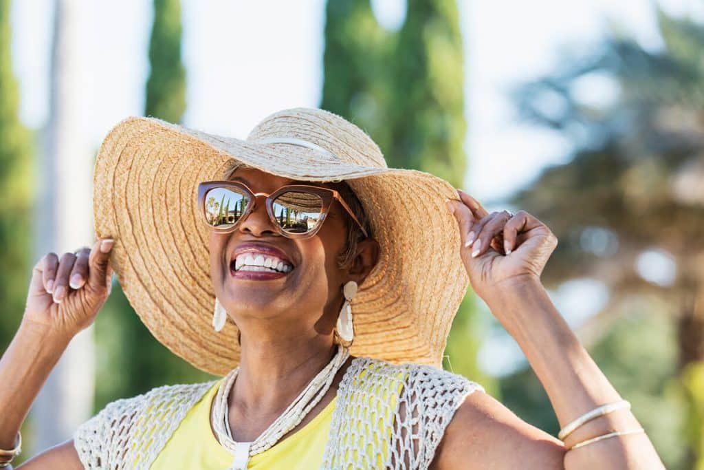 woman in sun hat and sunglasses smiling