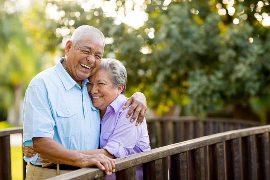 mature couple laugh and hug outside