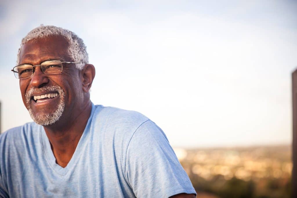 mature man in glasses laughing outside